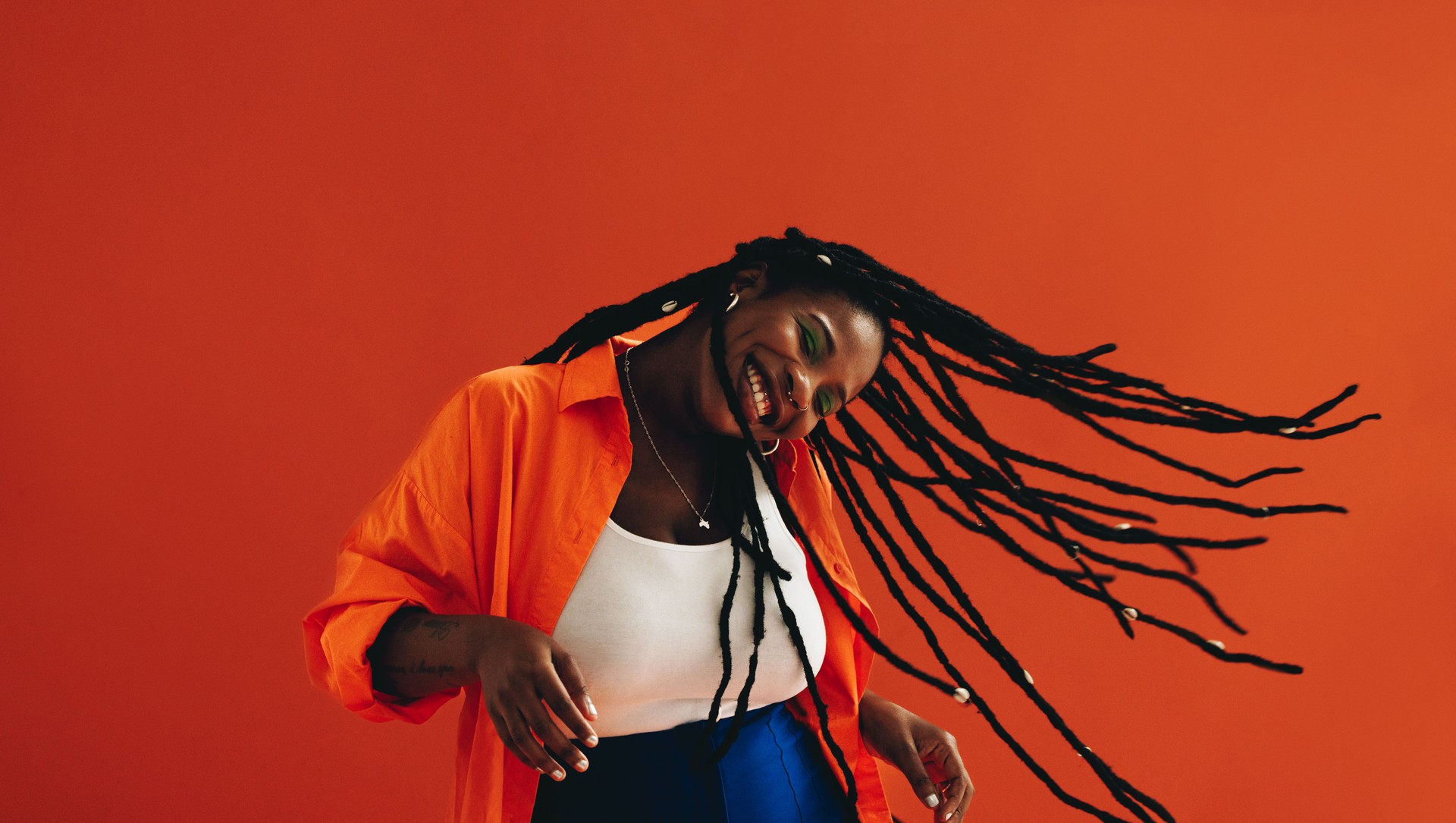 Vibrant young woman flipping her hair and having fun in a studio